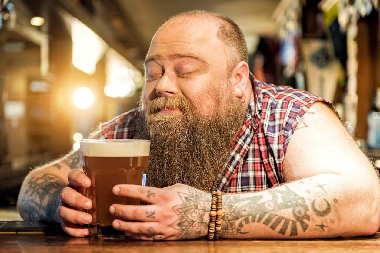 Delight bearded male drinking beverage in pub